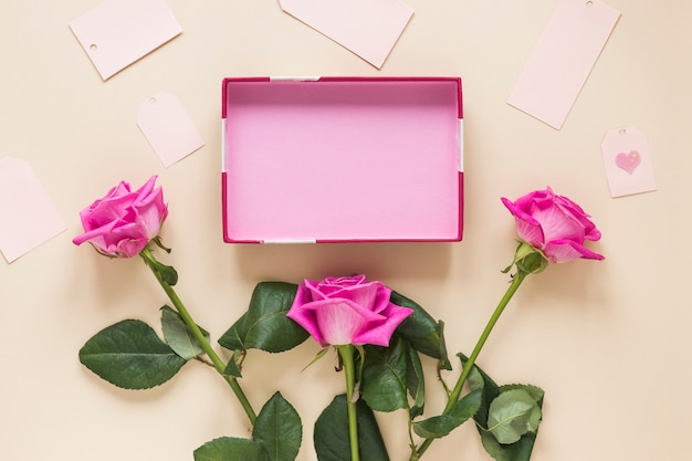 Free photo pink rose flowers with empty box on table