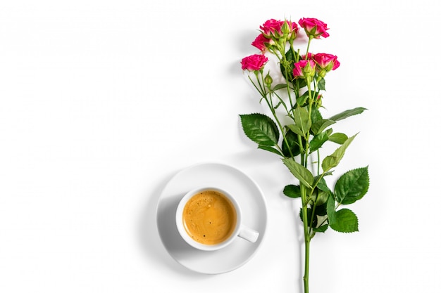 Pink roses with a cup of coffee isolated on a white background