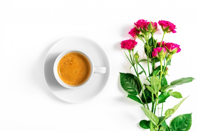 Pink roses with a cup of coffee isolated on a white background