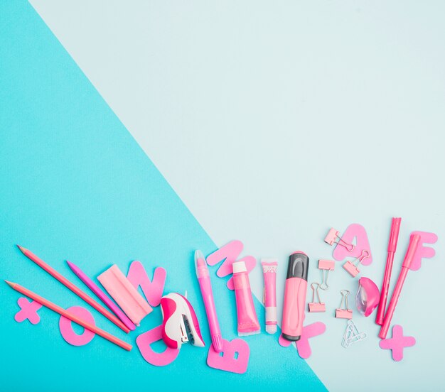 Pink school supplies and alphabets on dual color background