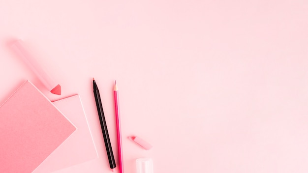 Pink set of office tools on colored surface