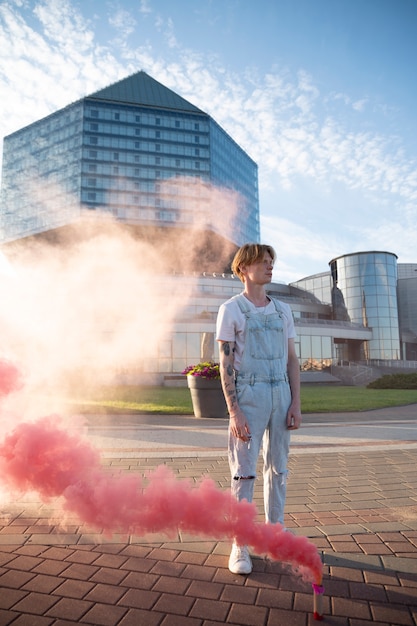 Foto gratuita sfondo rosa fumo con giovane adulto