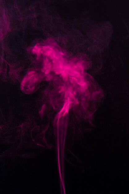 Pink smoke moving upward over the black background