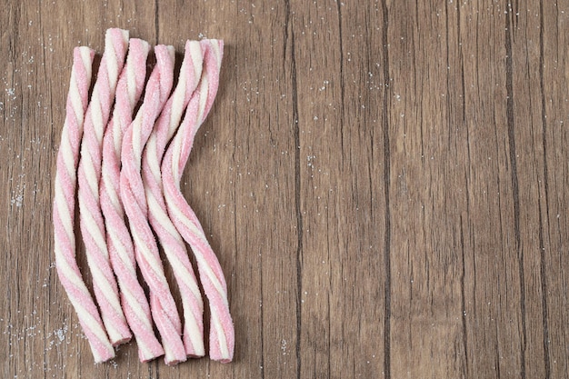 Pink spiral shape long jelly sticks on table.