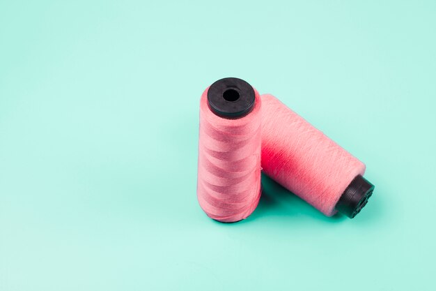 Pink spools on mint background