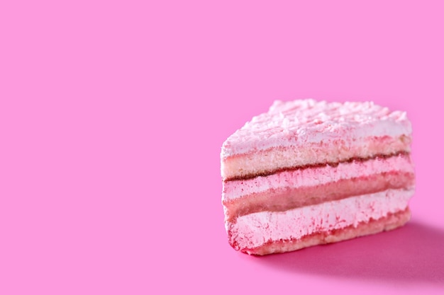 Pink strawberry cake portion on pink background