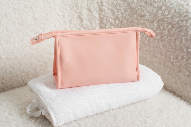 Free photo pink toilet bag on towel high angle