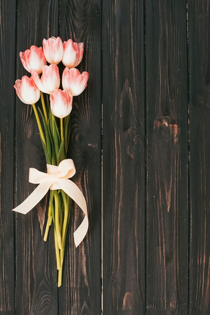 木製のテーブルにピンクのチューリップの花の花束