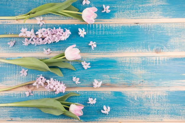 Foto gratuita tulipani rosa con fiori sul tavolo di legno