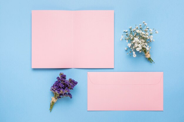 装飾用の花とピンクの結婚式の招待状