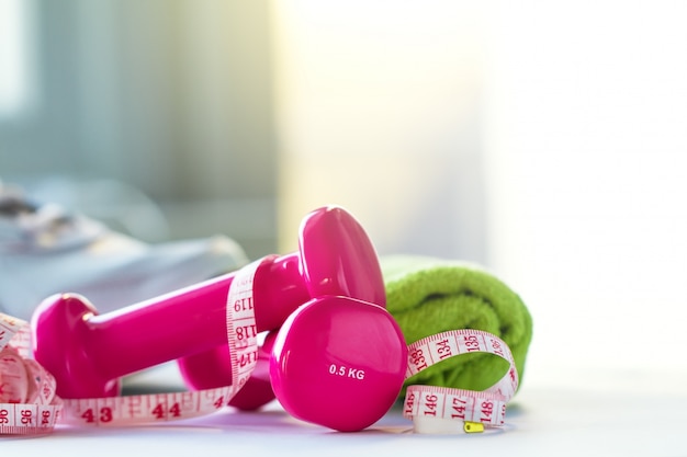 Pink weights, a tape measure and a towel