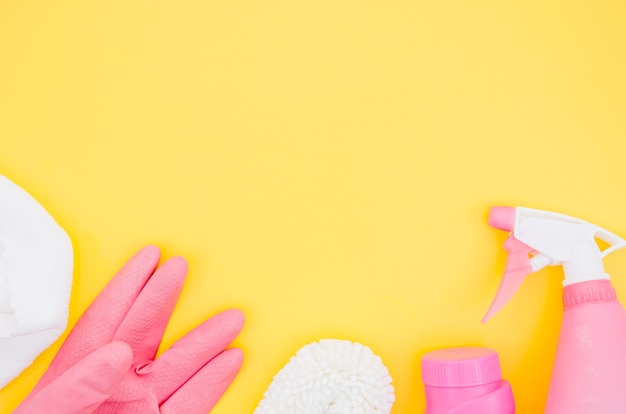 Pink and white cleaning supplies on yellow backdrop