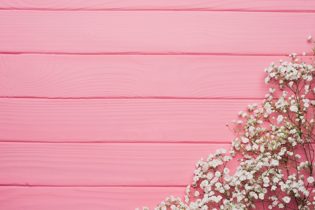 Free photo pink wooden background with floral decoration