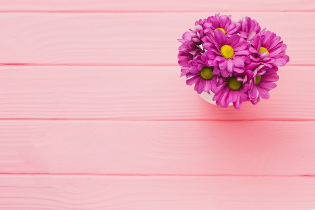 Pink wooden background with purple flowers