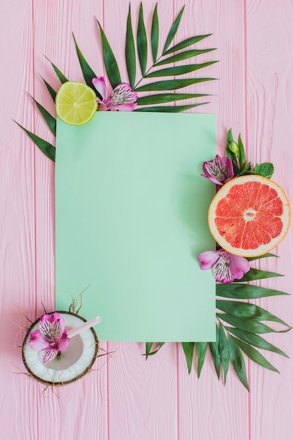 Pink wooden surface with paper for messages and decorative fruits