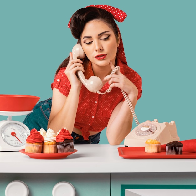 Free photo pinup girl posing in a kitchen