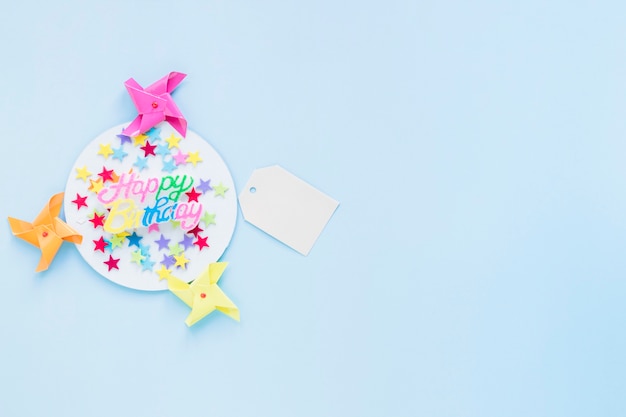 Free photo pinwheels and tag near confetti and birthday writing