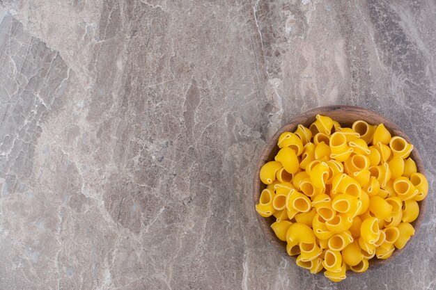 Pipe pasta in a bowl, on the marble surface