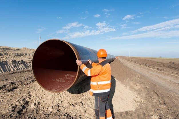 Pipeline workers measuring tube length for construction of gas and oil pipes