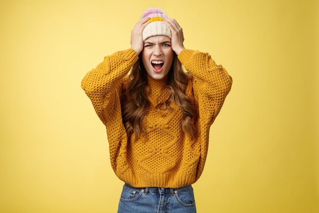 Free photo pissed annoyed freaked-out girlfriend jealous screaming pissed insane caught boyfriend cheating hold hands head shouting angry frowning cringing disgust dissatisfied look camera, yellow background