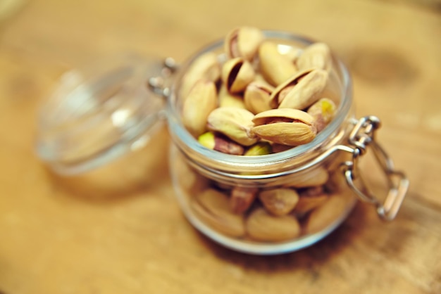 Pistachio nuts in bowl on old wooden table background