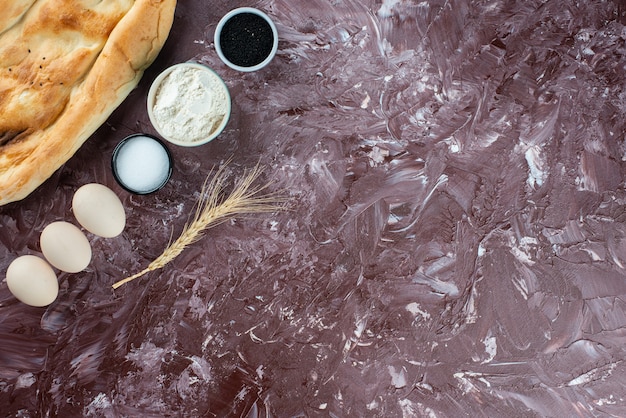 Pita flatbread with chicken eggs and flour on a light background. 