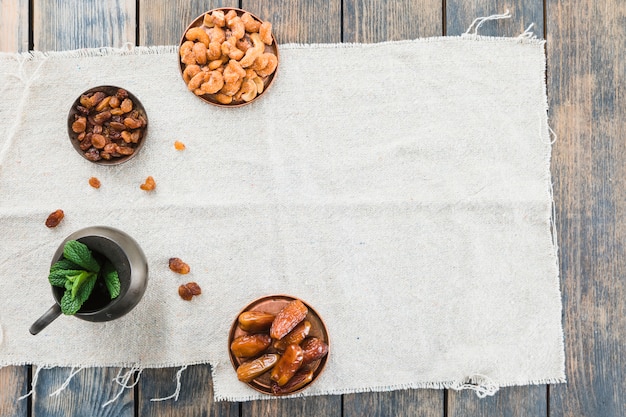 Free photo pitcher near dried fruits and nuts on textile