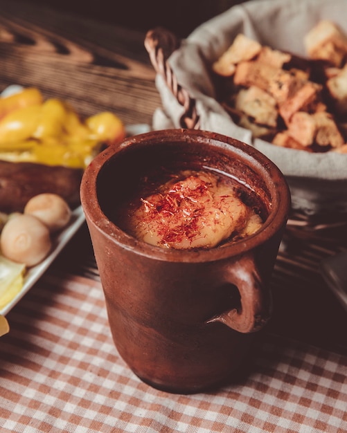 Free photo pitie in a clay pot and a basket of bread