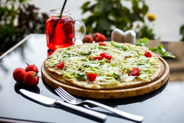 Пицца Цезарь на деревянной доске салат пармезан помидоры черри куриные крекеры вид сбоку
