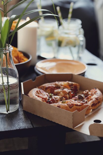 Pizza in a carton box and snacks
