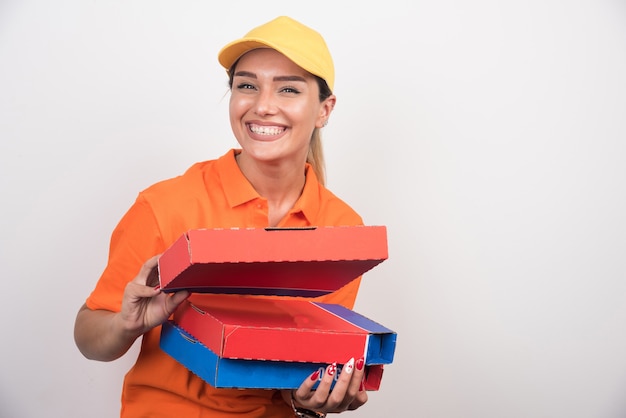 Женщина доставки пиццы, держащая коробки для пиццы на белом фоне.
