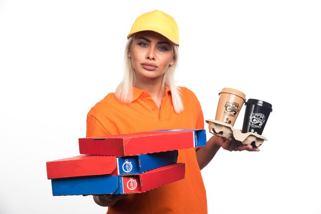 Женщина доставки пиццы, держащая пиццу и кофе на белом фоне. Фото высокого качества