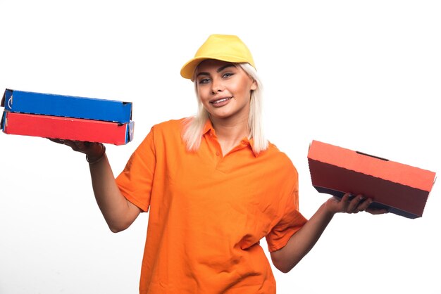 Pizza delivery woman holding pizza on white background while smiling. High quality photo