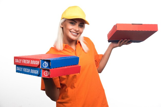 웃 고있는 동안 흰색 배경에 피자를 들고 피자 배달 여자. 고품질 사진