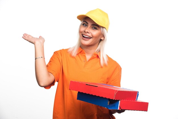 白い背景に彼女の手を示すピザを保持しているピザ配達の女性。高品質の写真
