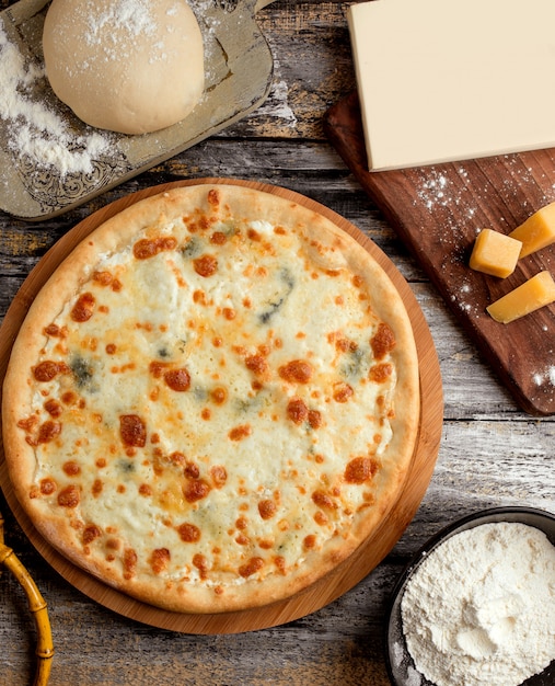 Foto gratuita pizza quattro formaggi sul tavolo