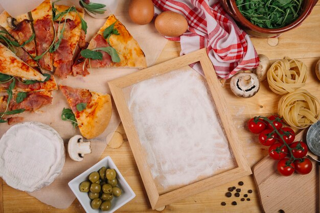 Pizza and ingredients near frame