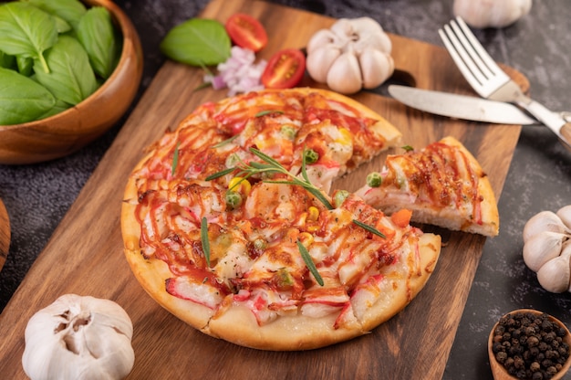 Pizza placed on a wooden plate.