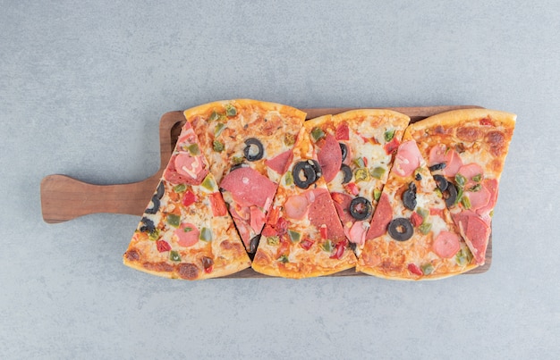 Pizza slices bundled on a small tray on marble 