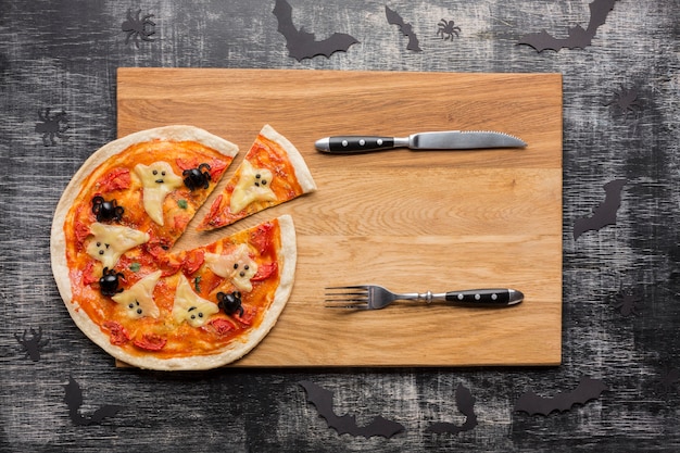 Pizza slices with halloween ghosts and cutlery