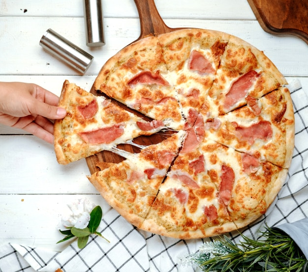 Foto gratuita pizza con prosciutto sul tavolo
