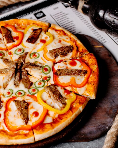 Pizza with meat, bell peppers and chili peppers