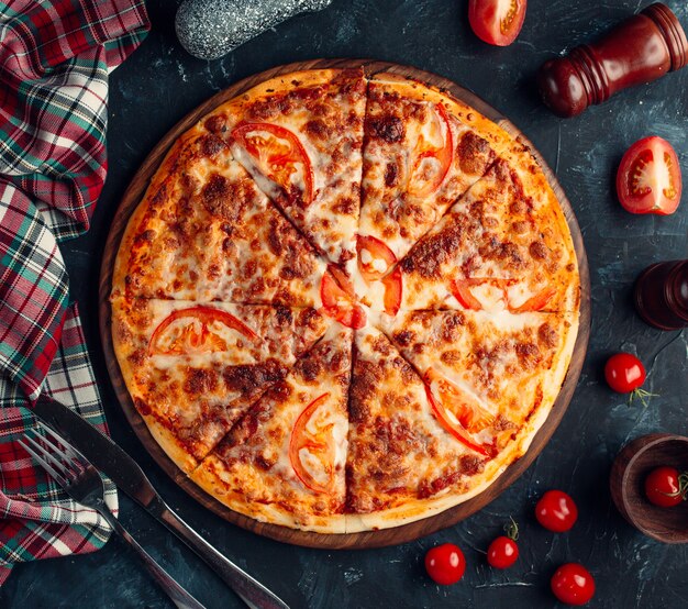 Pizza with meat stuffing and tomato slices.