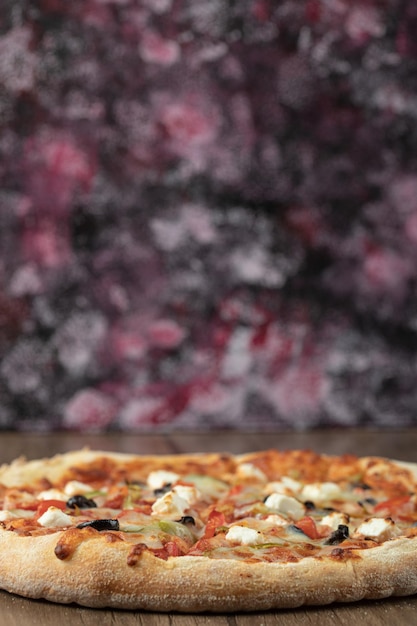 Бесплатное фото Пицца с смешанными ингредиентами и нарезанным белым сыром.