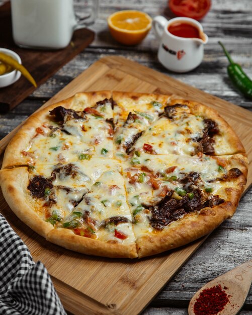 Pizza with mixed ingredients on a wooden board.