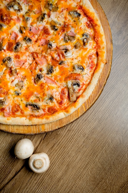 Pizza with mushrooms, ham and herbs