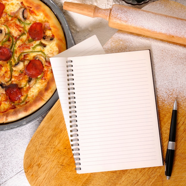 Free photo pizza with notebook