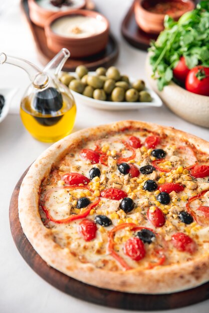 Pizza with olives bell peppers tomatoes and corn