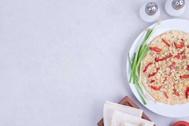 Pizza con peperoni e cipolla sulla zolla bianca.