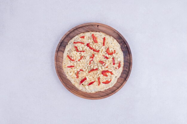 Foto gratuita pizza con peperoni sul piatto di legno